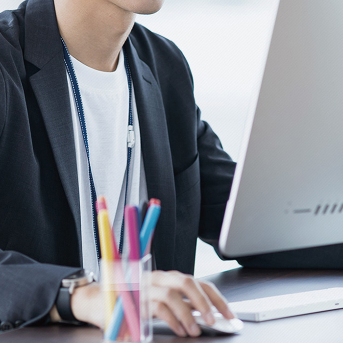 モニターに向かいデザインしている。「プロダクションプレス事業部」のイメージ写真