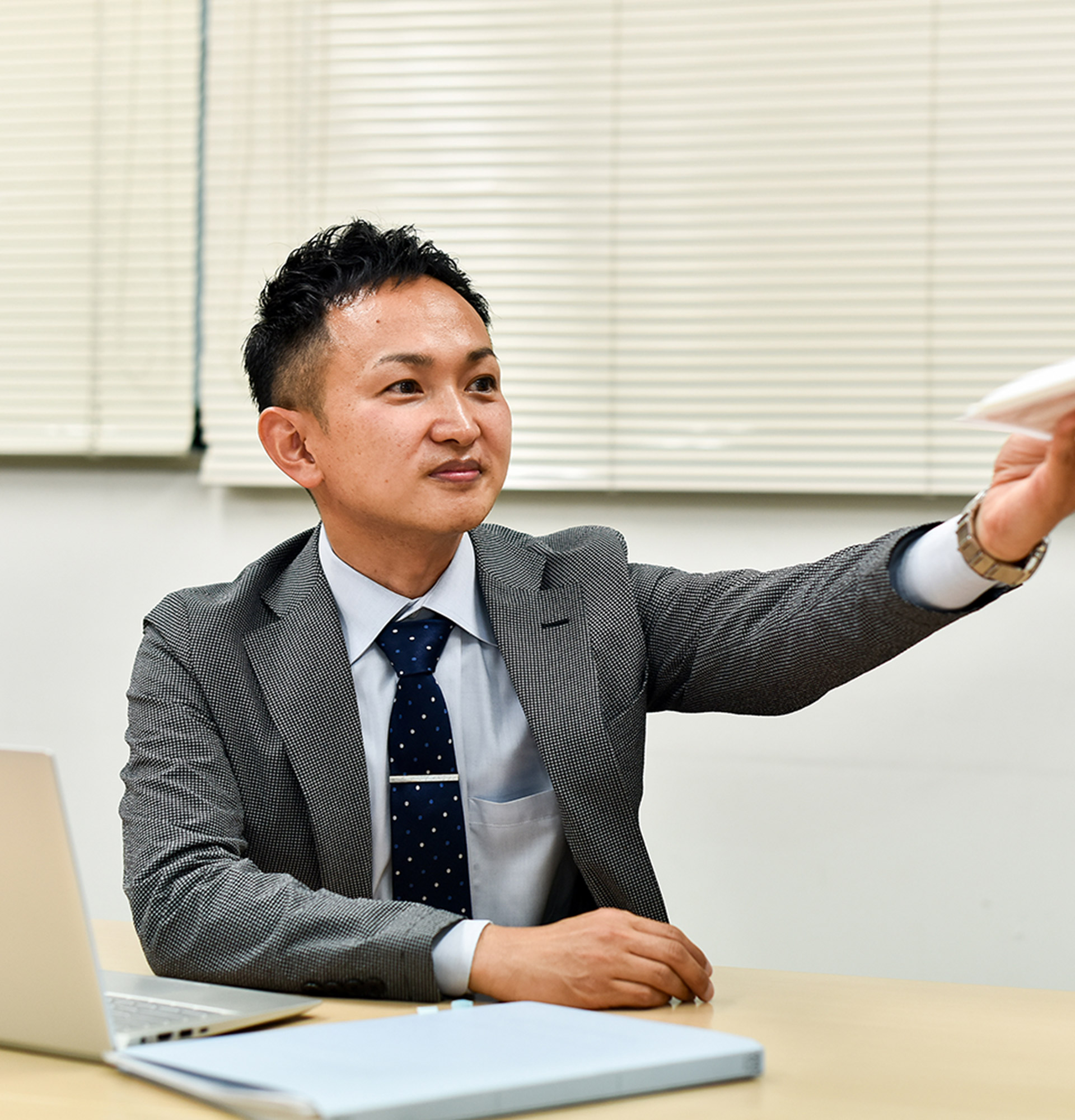 確認した書類を手渡している社員